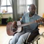 Disabled man tuning a guitar for playing